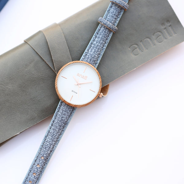 Wristwatch with gray textured strap on a white background