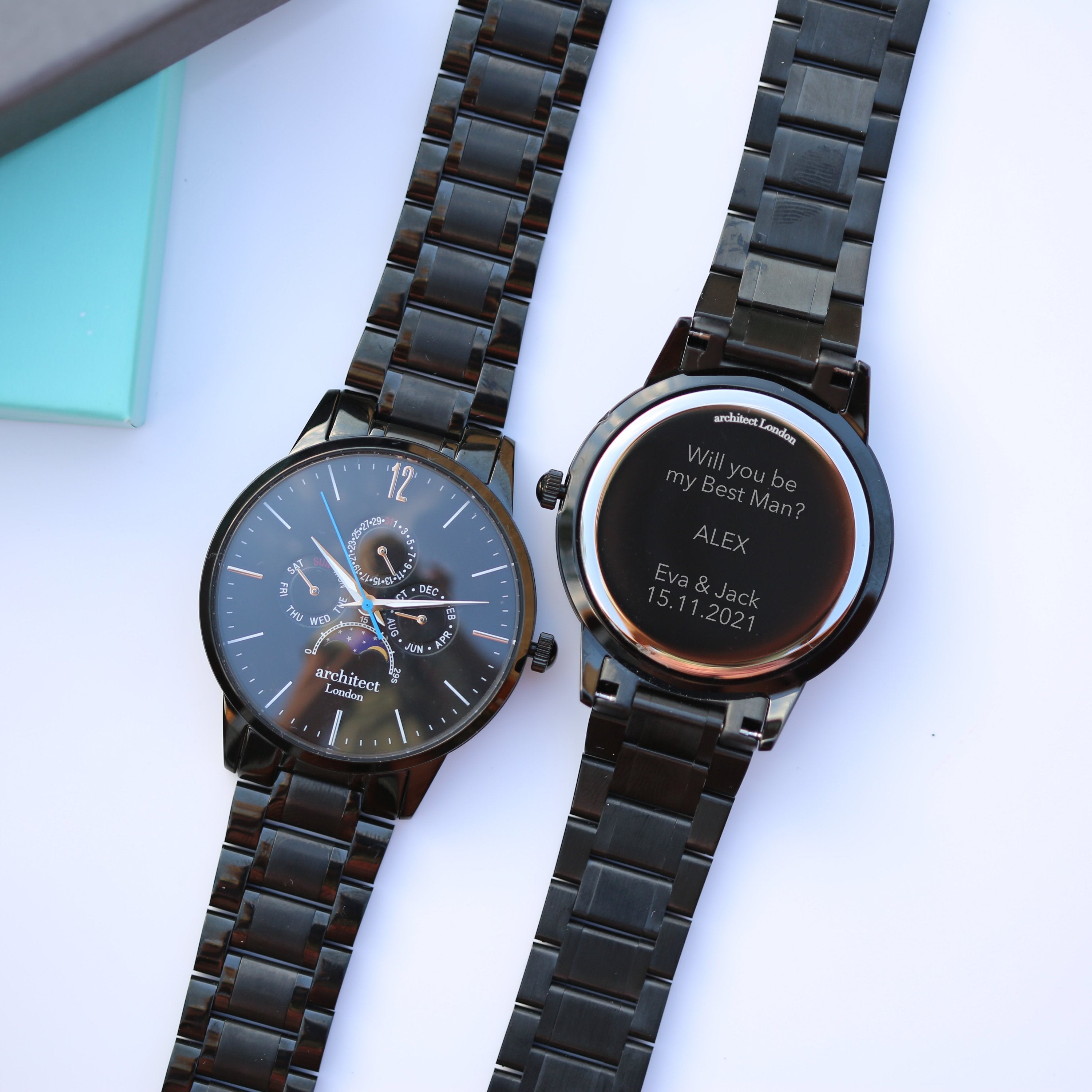 Two black watches with engraved messages on a white surface