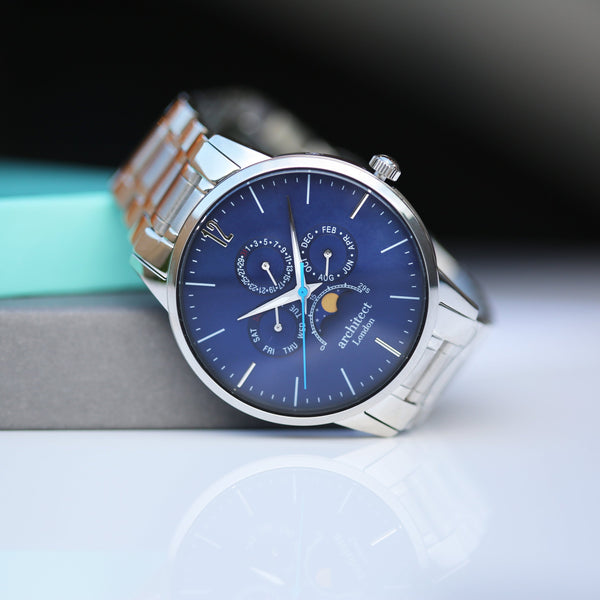 Wristwatch with a blue face and silver case on a light background