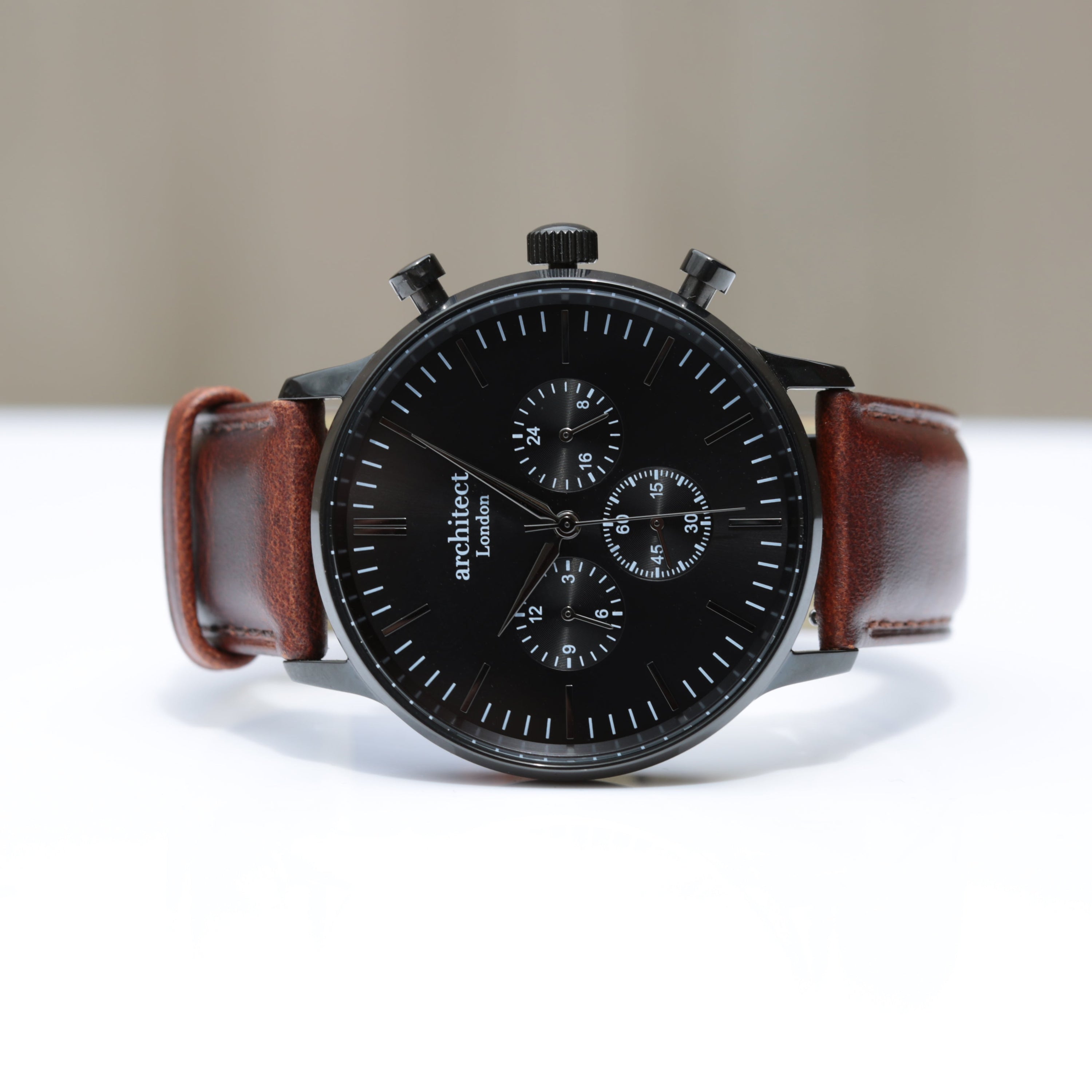 Watch with a brown leather strap on a white surface
