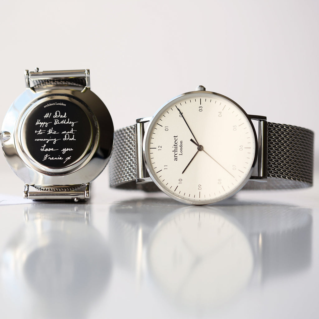 Two watches on a reflective surface with a light gray background