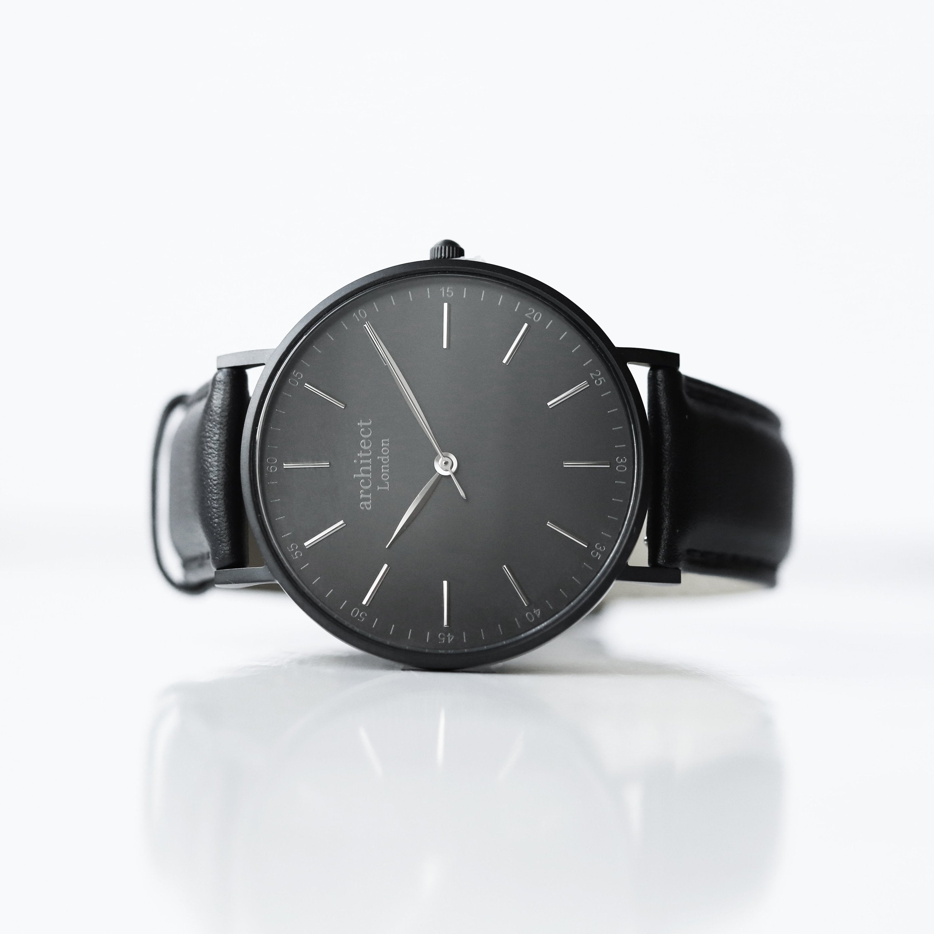 Black wristwatch with a reflective surface on a white background