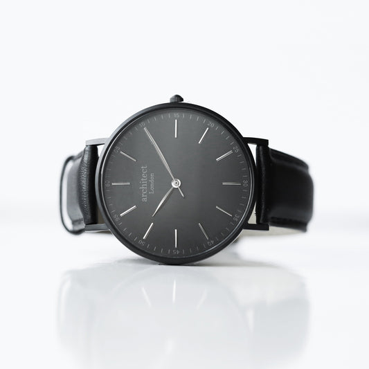 Black wristwatch with a reflective surface on a white background