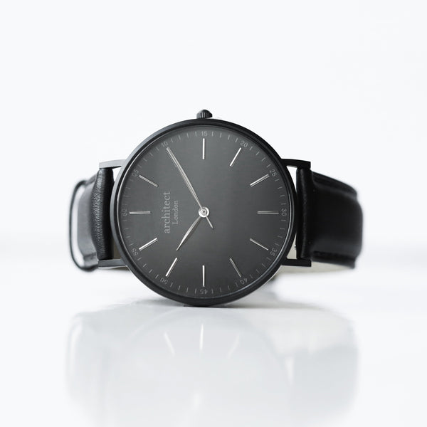 Black wristwatch with a reflective surface on a white background