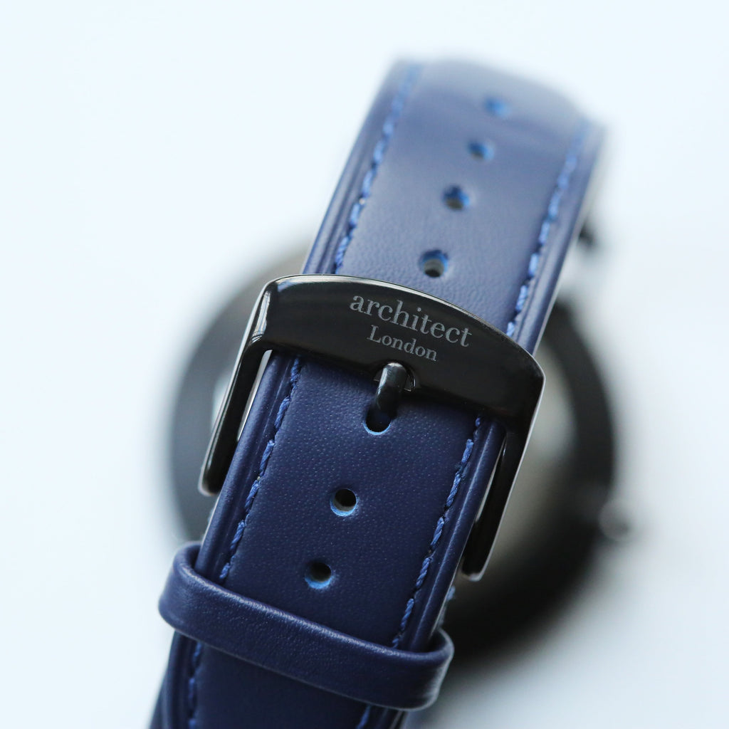 Close-up of a blue leather watch strap with 'architect London' buckle on a light gray background