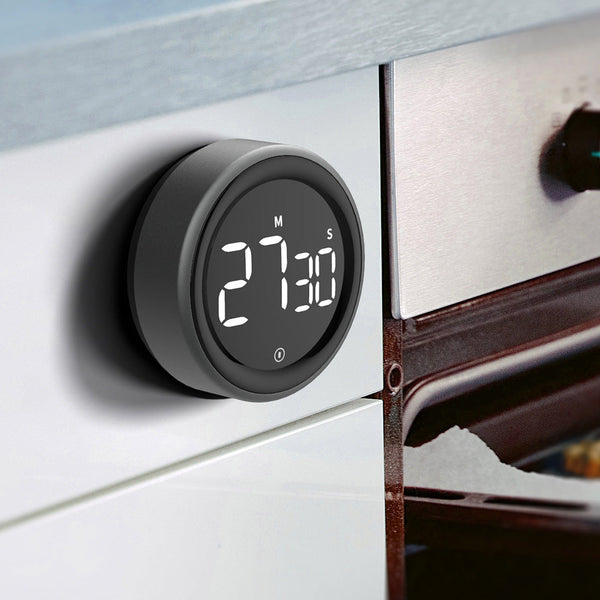 Digital timer on a kitchen appliance with a close-up of chocolate being baked.
