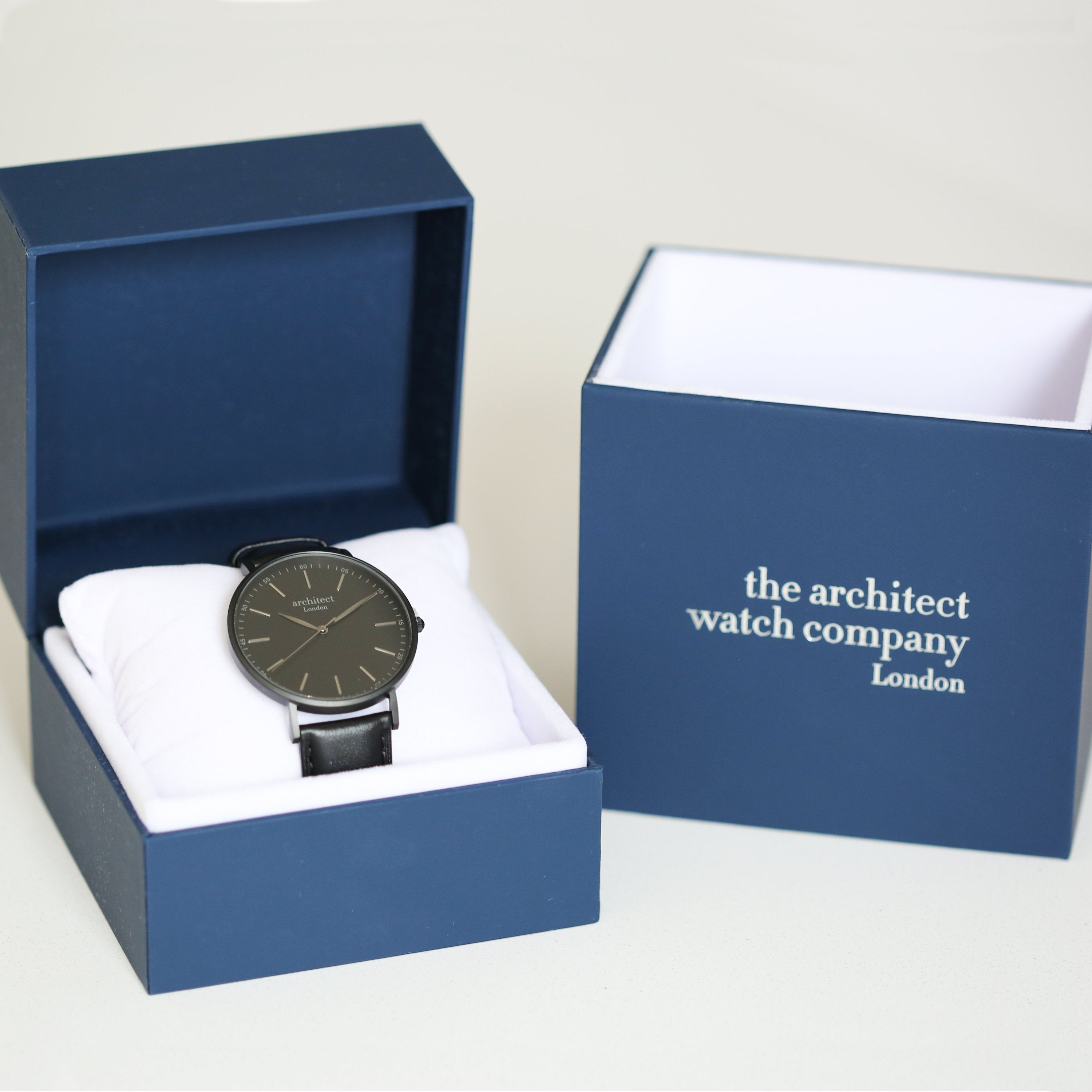 Watch in a blue box with 'the architect watch company' branding on a white background