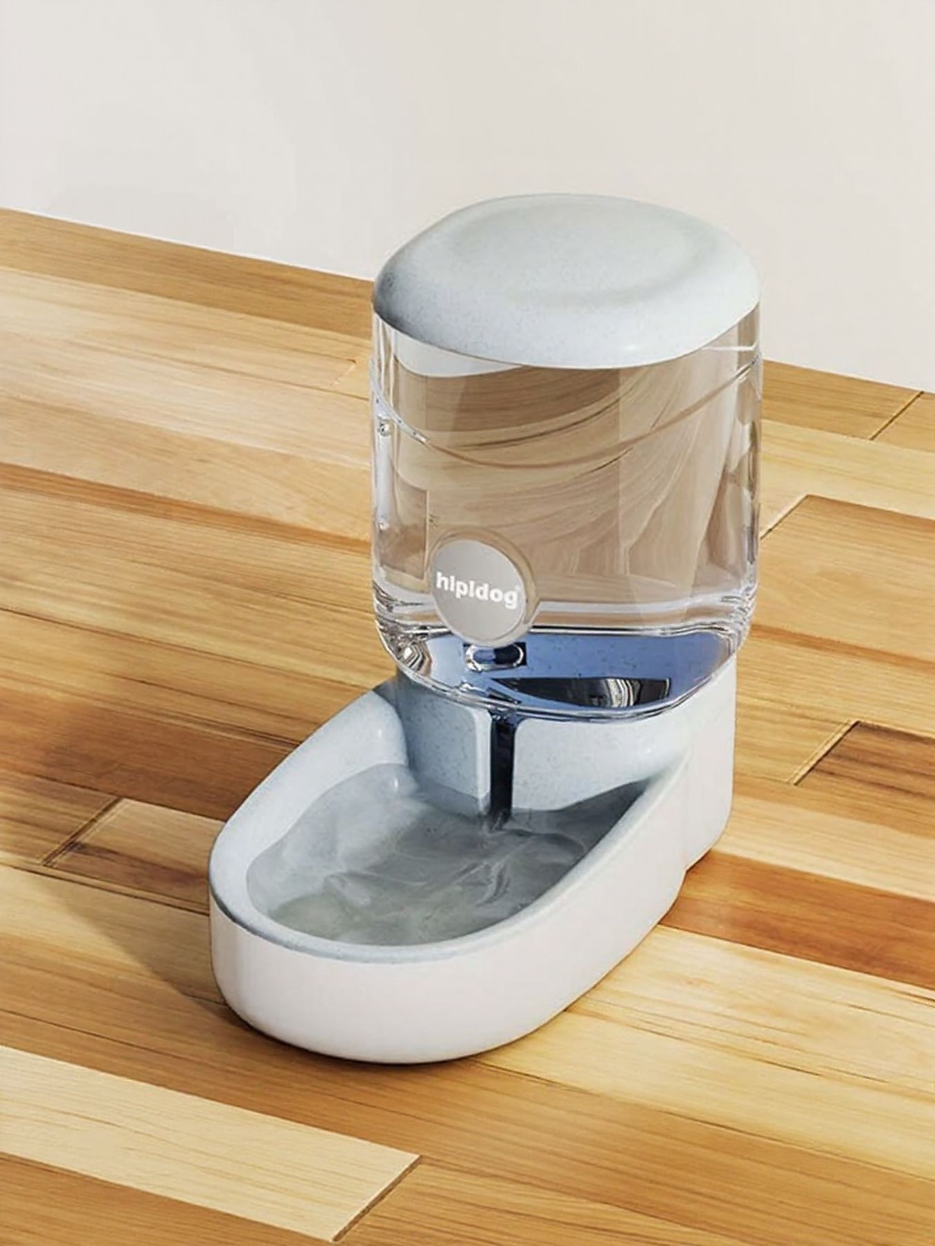 Pet water fountain with clear reservoir on a wooden floor