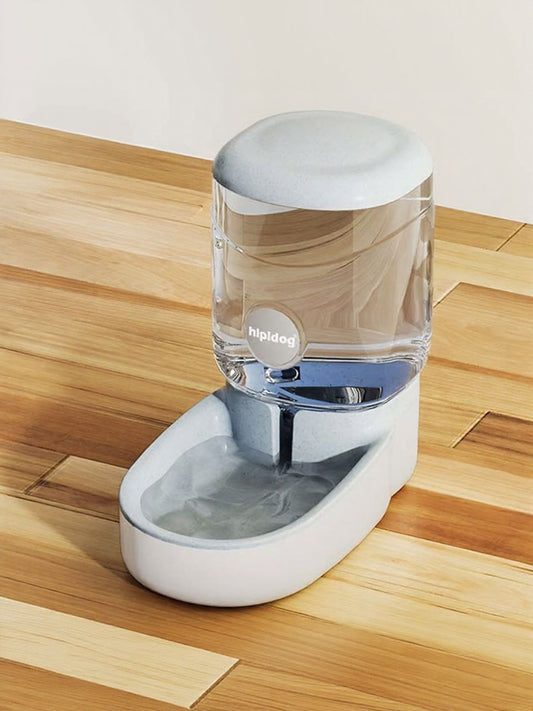 Pet water fountain with clear reservoir on a wooden floor