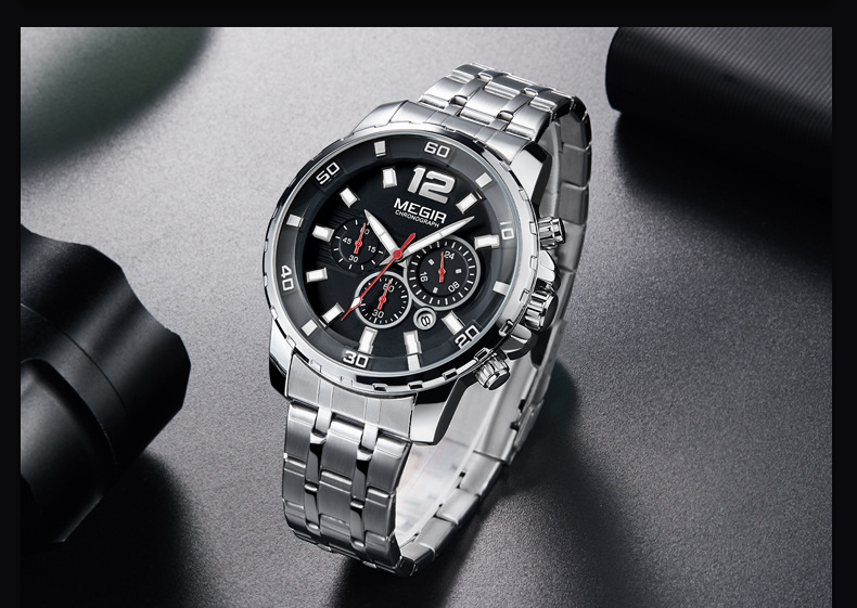 Silver wristwatch with black face on a dark surface