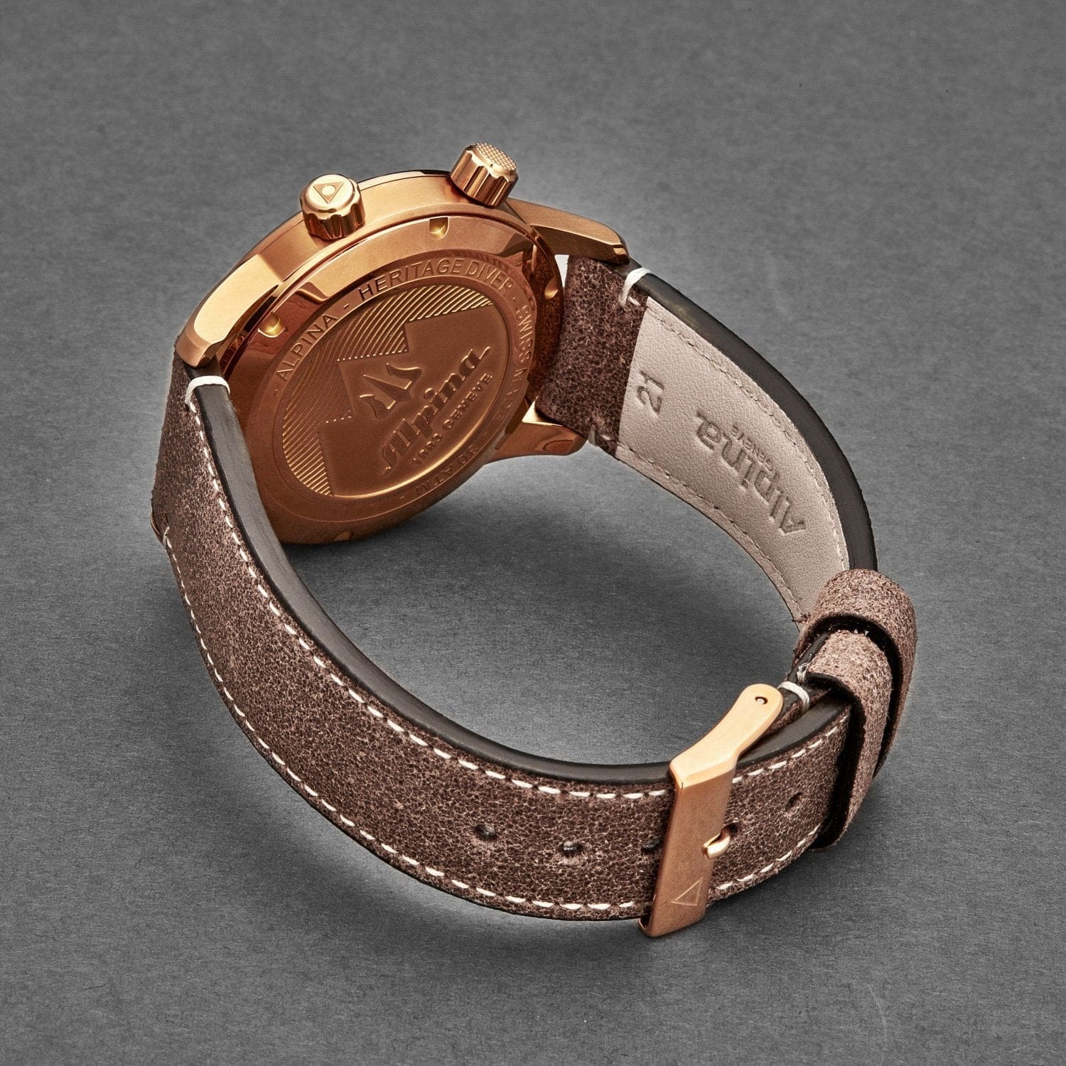 Brown leather watch with gold accents on a gray background