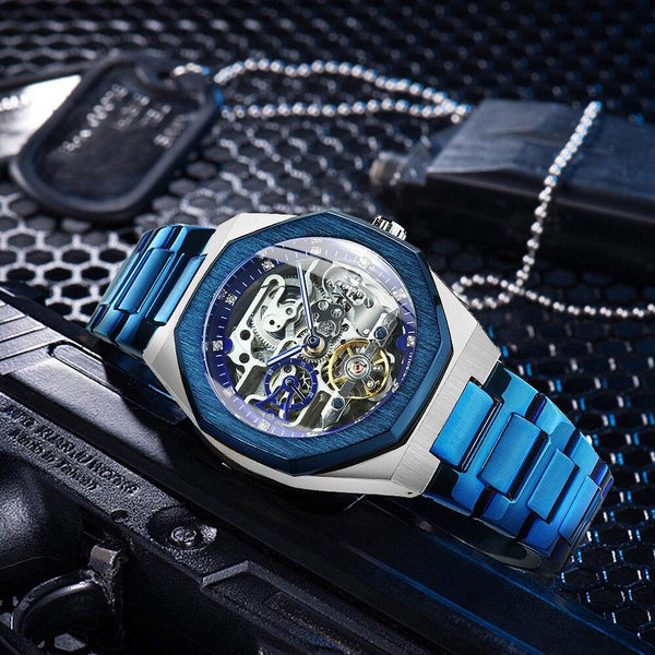 Blue and silver watch with intricate design on a textured black background